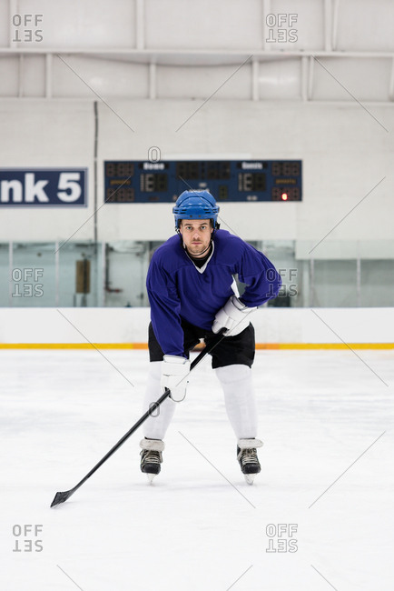 Full length portrait of male player playing ice hockey at rink