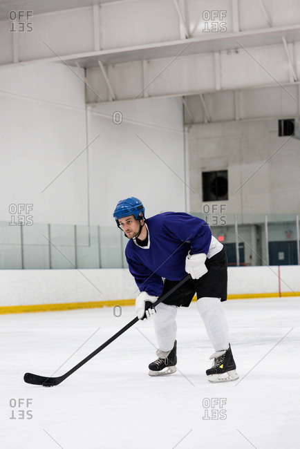 Full length of determined male player practicing ice hockey at rink