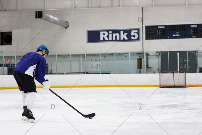 Full length of male ice hockey player practicing at rink