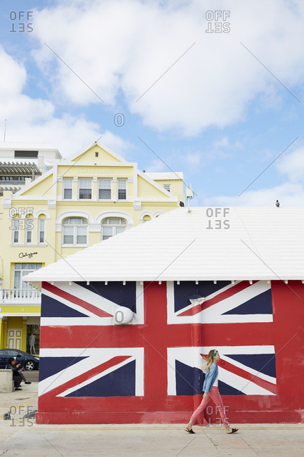 Hamilton, Bermuda - March 25, 2017: Girl walking past British flag