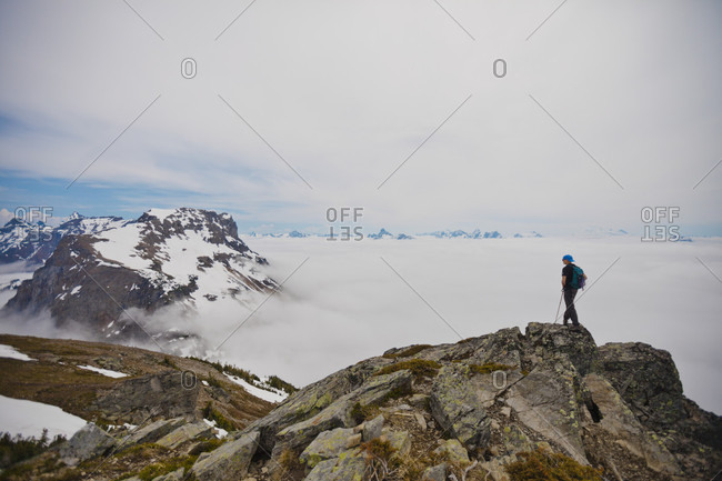 Hiker standing in natural scenery on mountain peak overlooking Lady Peak, Chilliwack, British Columbia, Canada
