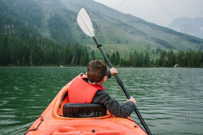 Boy kayaking in mountain lake