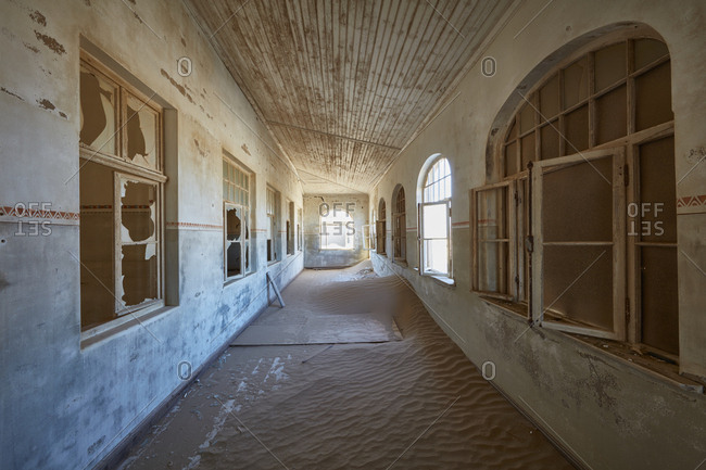 A view of a corridor in a derelict building full of sand