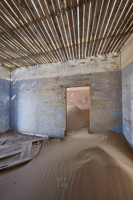 A view of a room in a derelict building full of sand