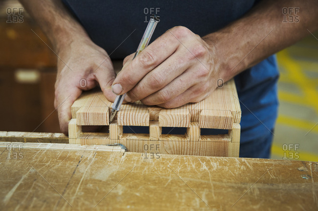 Close up of person working a boat-builder\'s workshop, joining together two pieces of wood