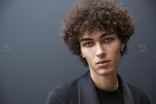 England - June 11, 2017: Close up portrait of mixed race young male fashion model black wall during London Week Men's stock photo - OFFSET