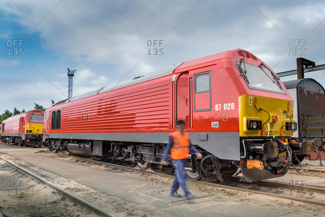 Locomotive engineer walking by locomotive in train works