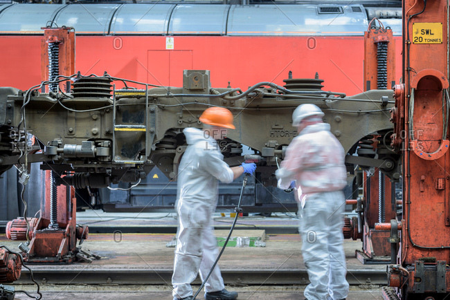 Locomotive engineers working on locomotive in train works