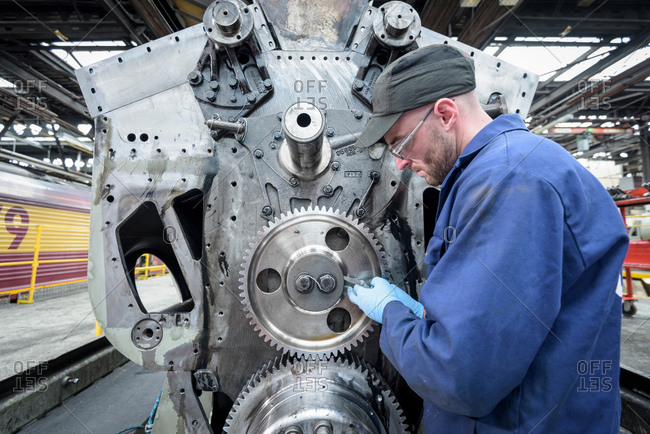 Engineer maintaining locomotive engine in train works