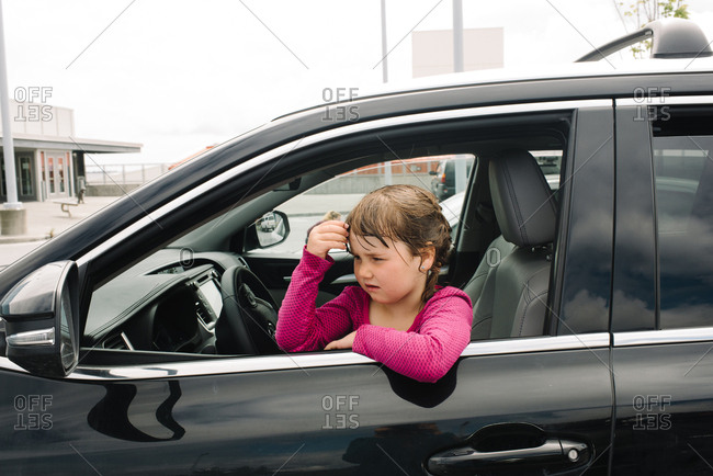 Girl staring out from front seat of car