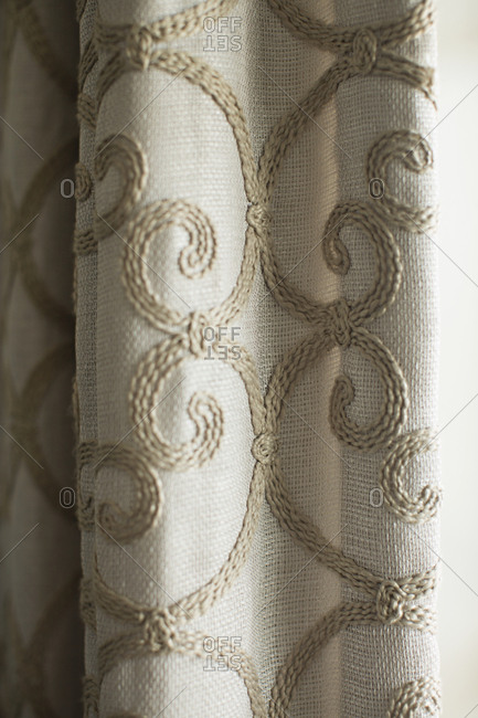 Close up of curtains with embroidered swirl pattern