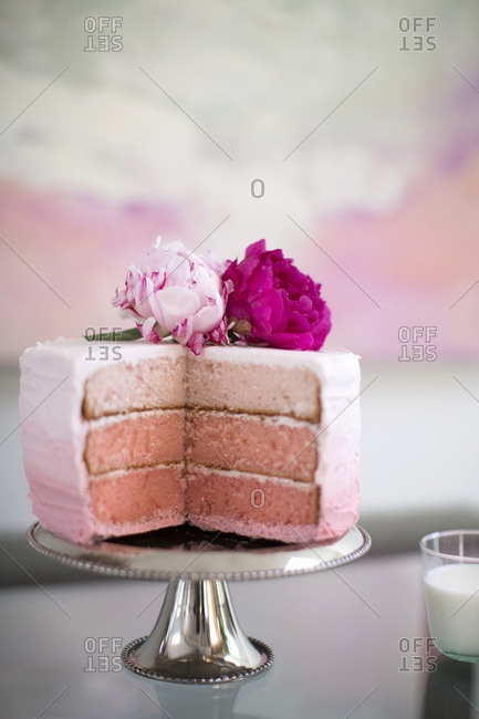 Three layered gradient strawberry cake topped with flowers