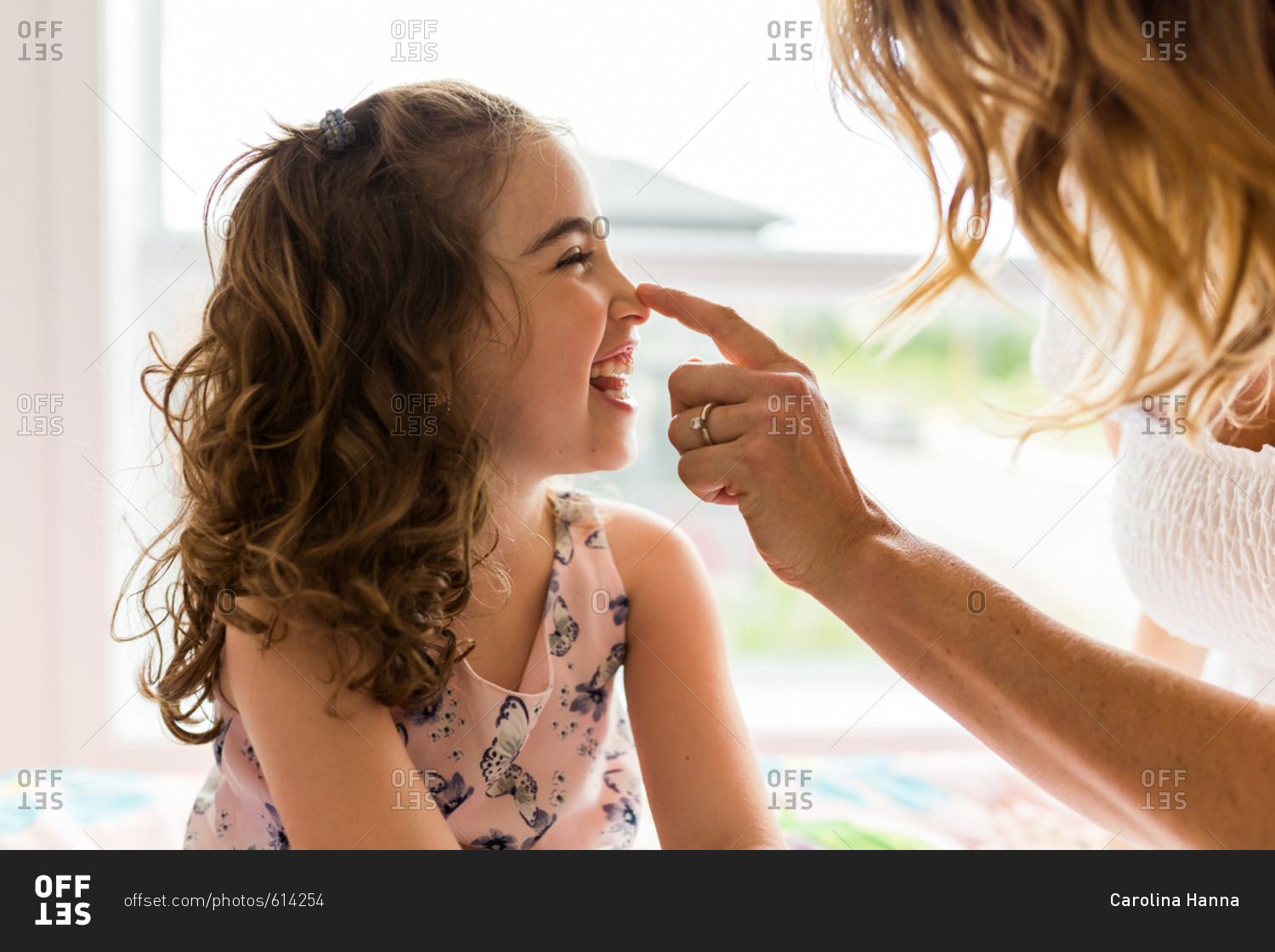 mother-touching-her-daughter-s-nose-stock-photo-offset