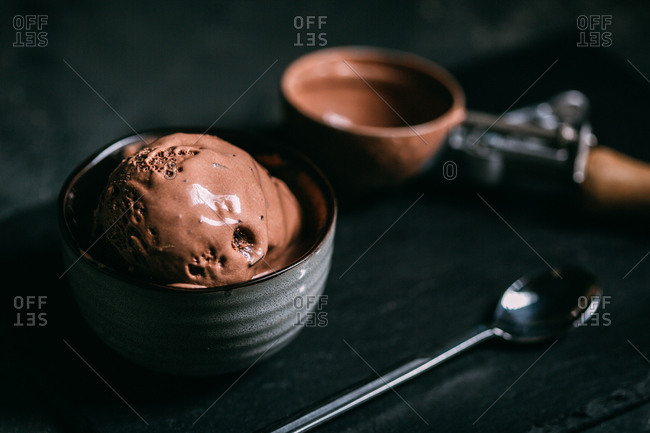 Chocolate ice cream in a scoop on dark background stock photo - OFFSET