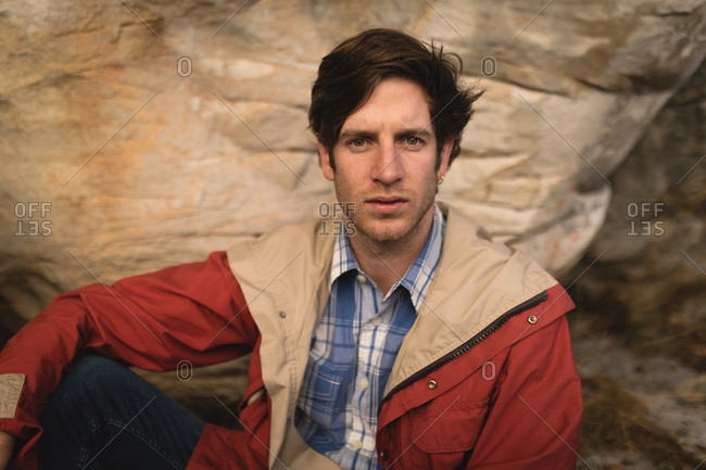 Confident man relaxing on rock