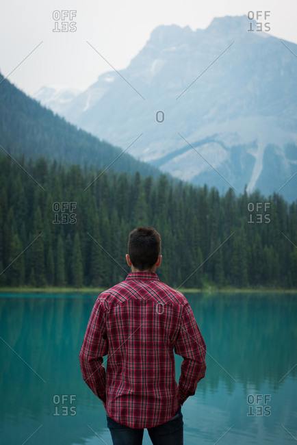 Rear view of man standing near the lake
