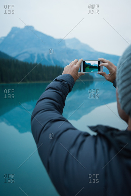 Rear view of man taking a picture with his mobile phone