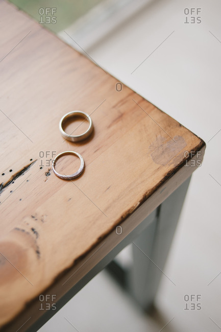 Two wedding bands on a wooden table