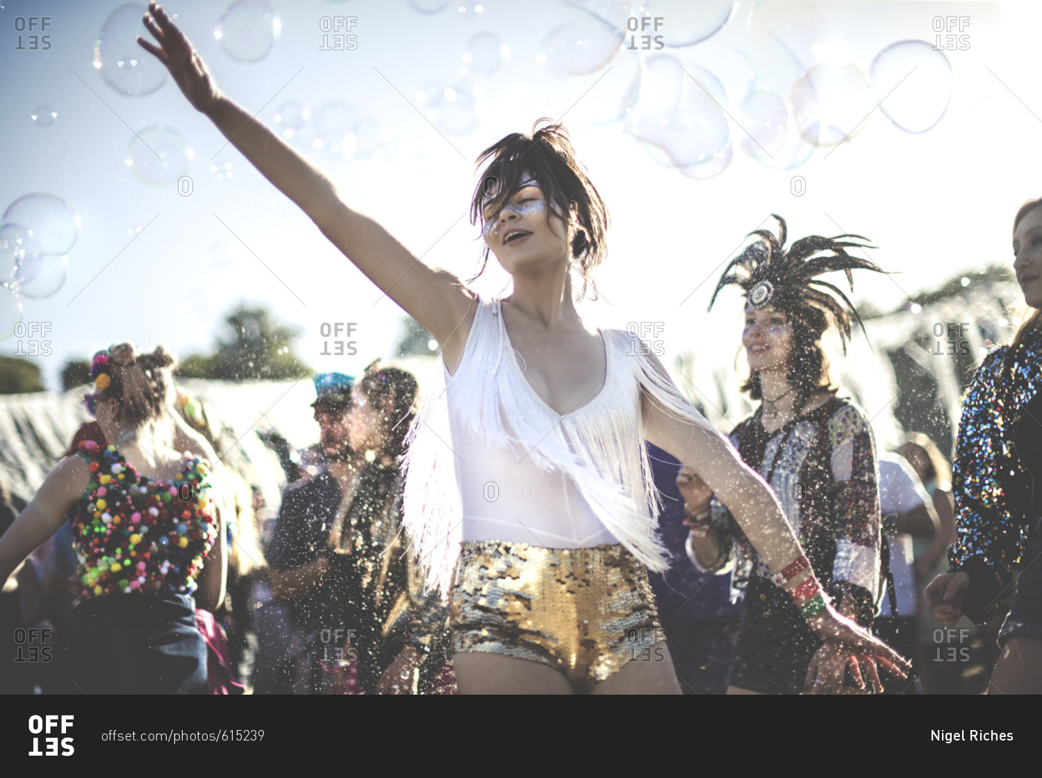 Festival goers dancing with bubbles at a concert