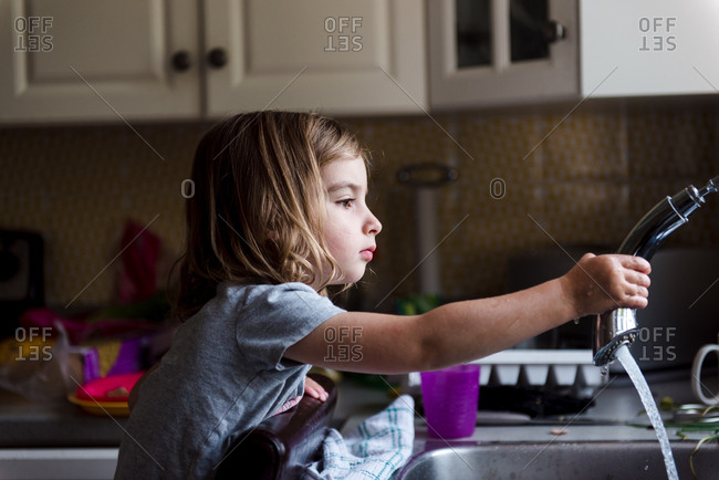 Little Girl Spraying Kitchen Faucet Stock Photo Offset