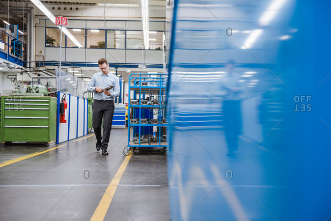 Factory manager walking and inspecting product in factory