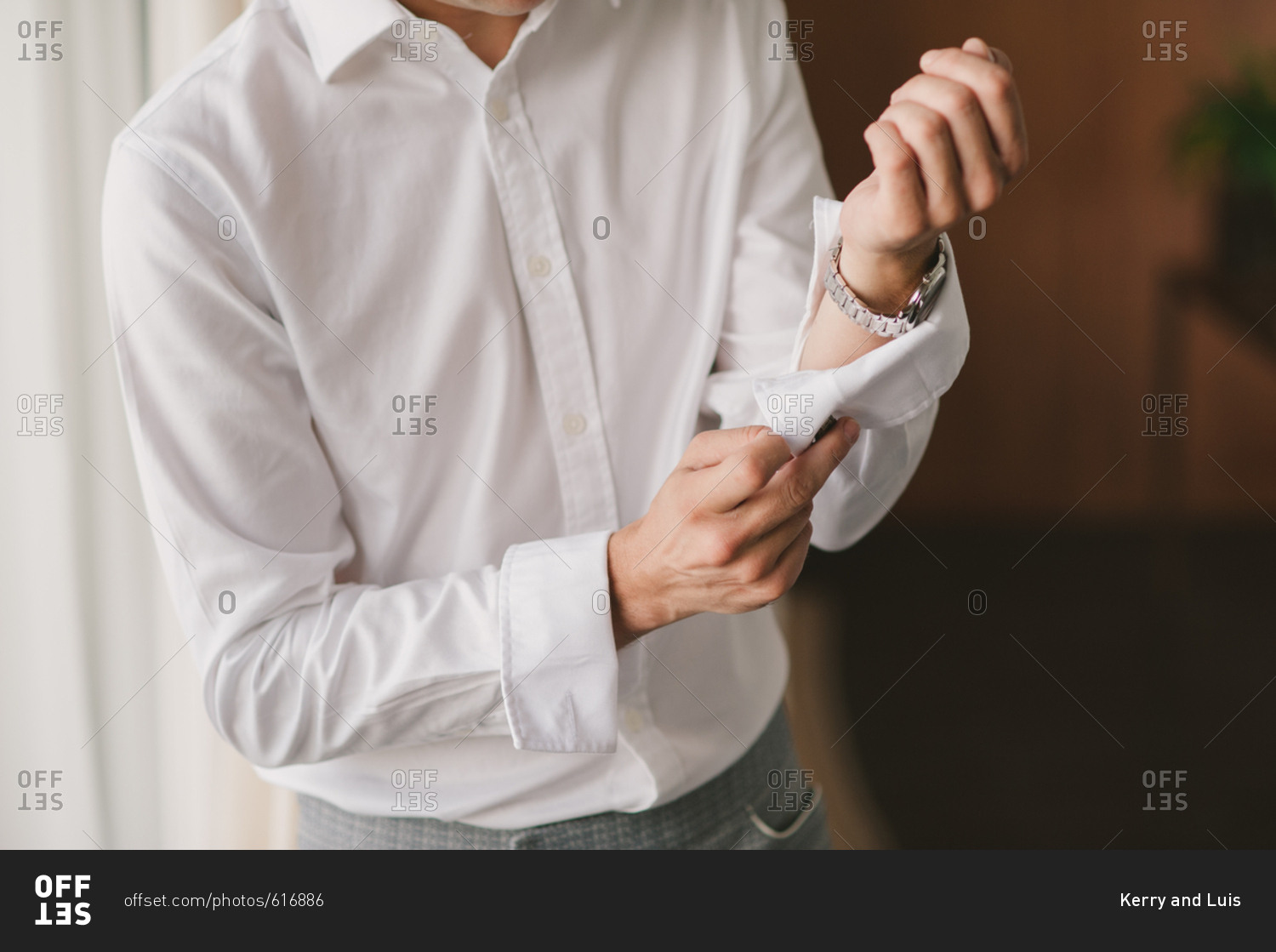 Man adjusting sleeve on dress shirt stock photo OFFSET