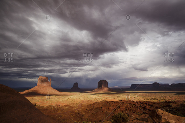 Scenic view of Monument Valley with dark clouds