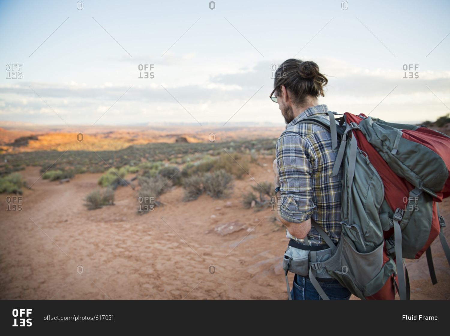 Man hiking a red dirt trail