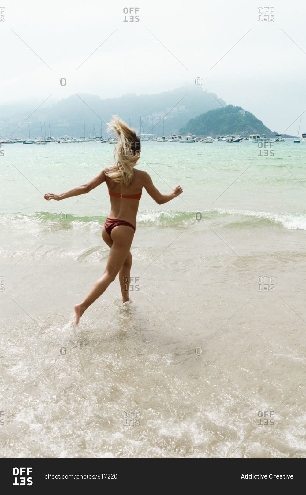 Happy woman running on tropical beach
