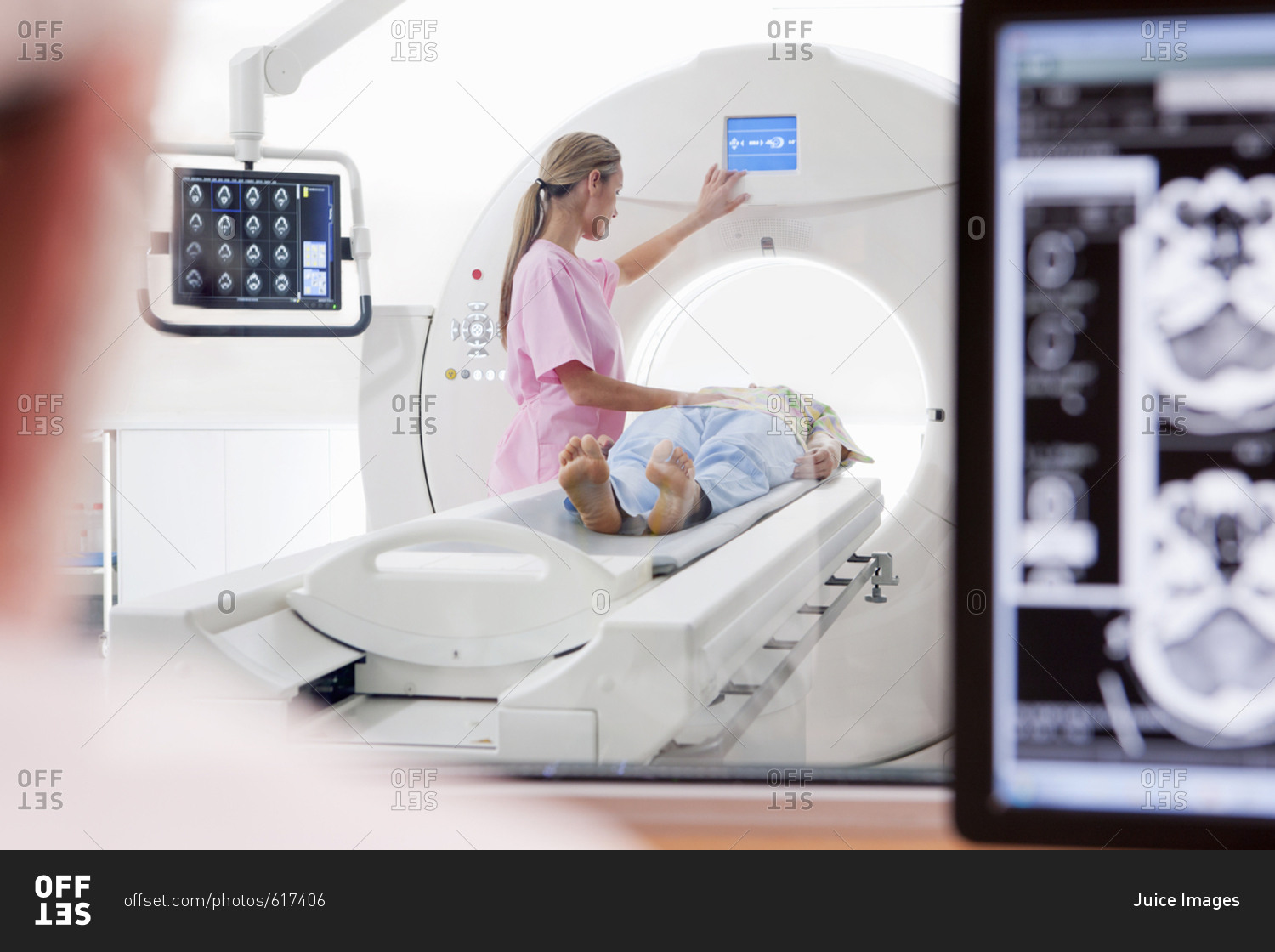 Nurse technician and patient at CT scanner in hospital with digital brain scan in foreground