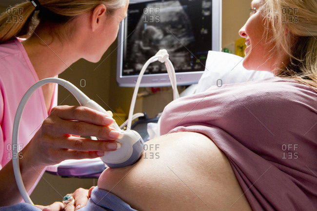Close up nurse performing ultrasound on pregnant woman in hospital