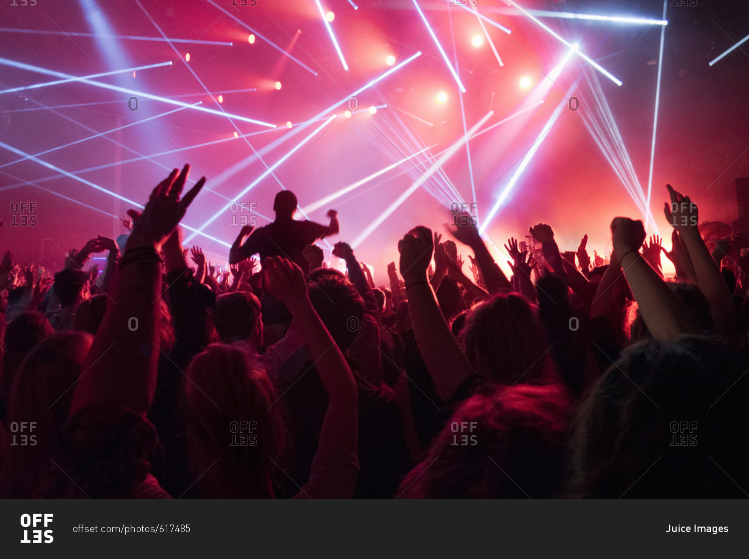 View Of Fans Enjoying Rock Concert With Light Show stock photo - OFFSET
