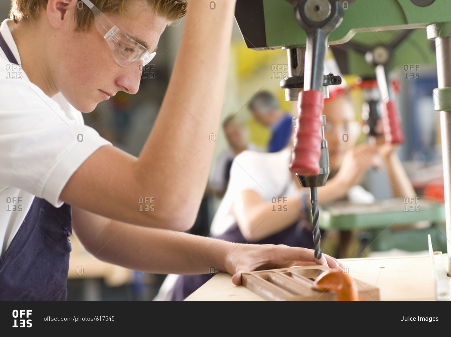 Serious student using drill in vocational school