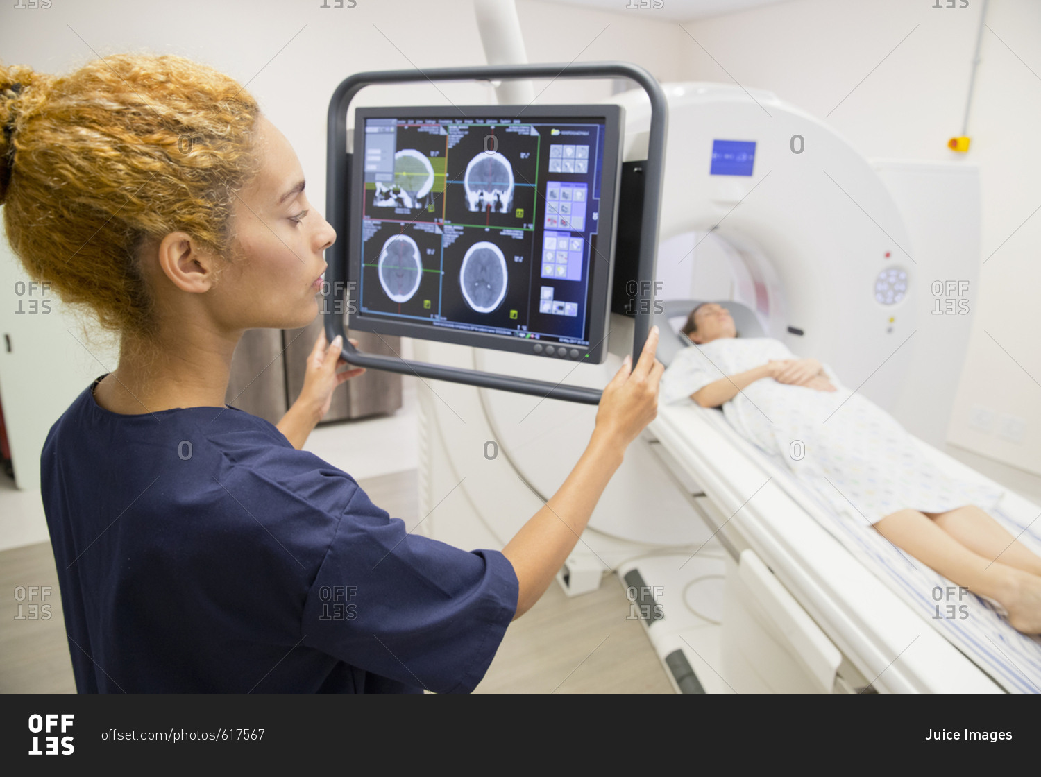 Hospital Radiographer With Female Patient Operating CT Scanner stock