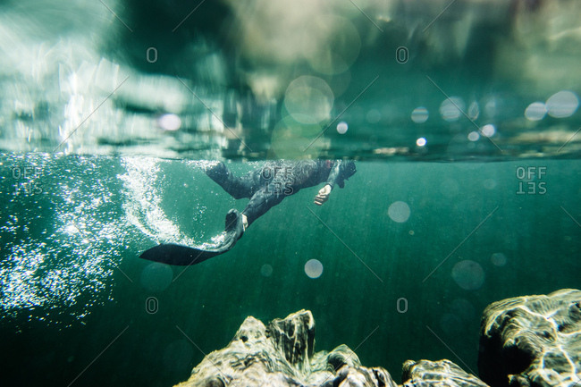 Underwater view of diver wearing flippers swimming in the ocean