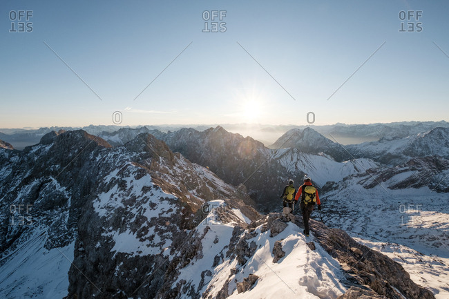 Two mountaineers climbing on mountain peak in European Alps