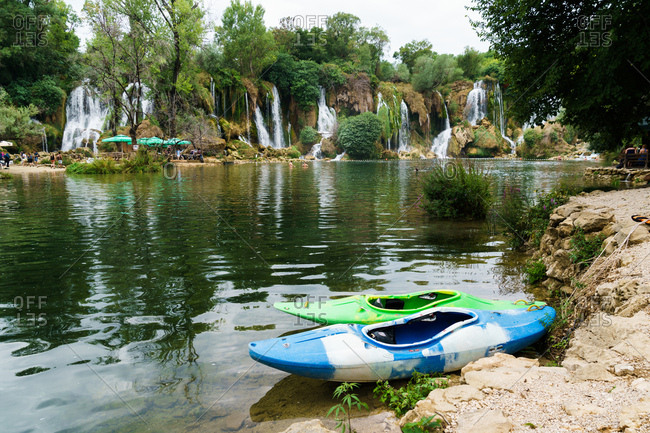 Boats on lake with waterfall