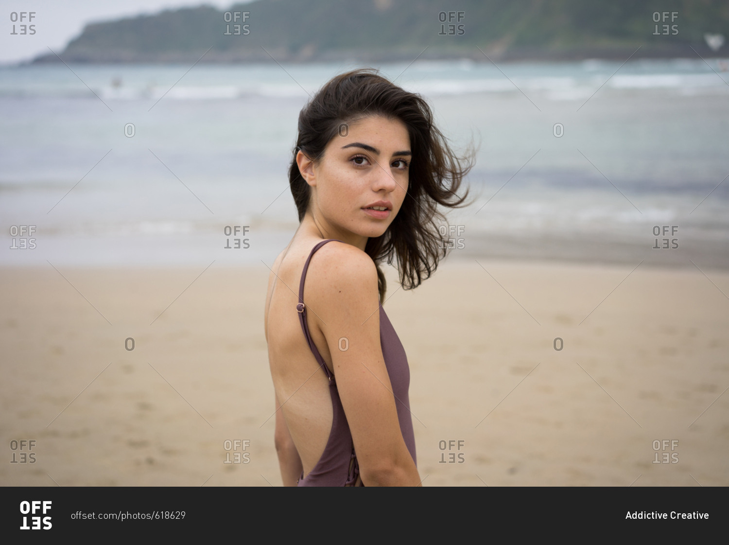 Slim girl in swimsuit on beach stock photo - OFFSET