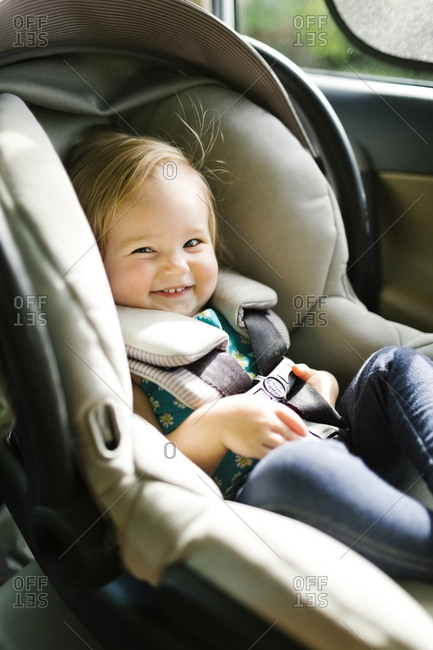 Baby girl (12-17 months) sitting in baby car seat during car trip