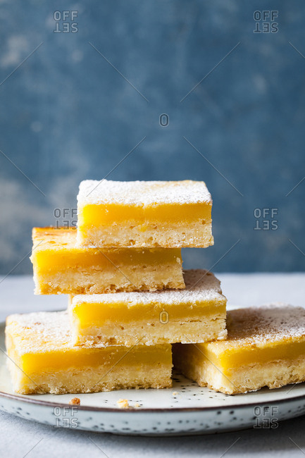 Stacked lemon squares on a blue background