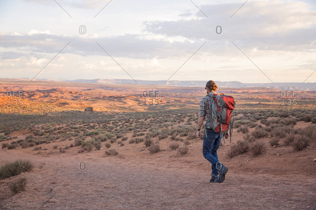 Man hikes a red dirt trail