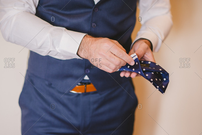 Groom folding his pocket square