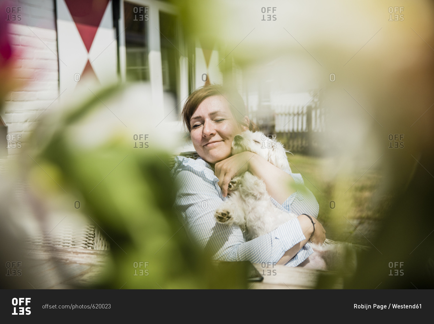 Woman cuddling with dog on terrace