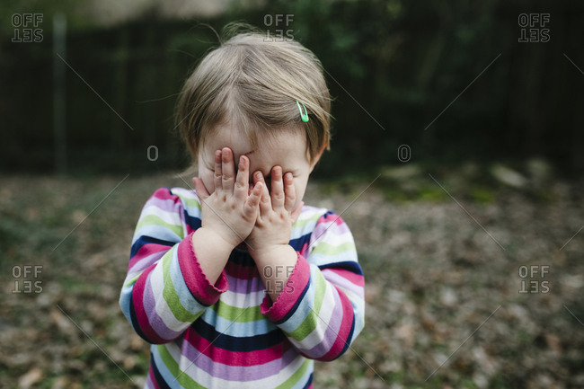 Girl covering her face with her hands
