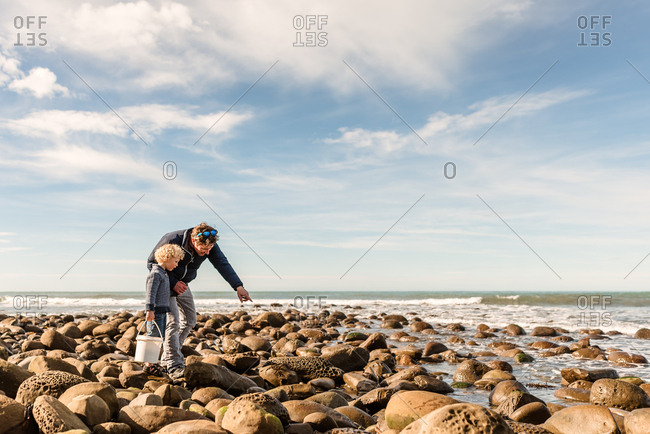 Father and son exploring rocky coast