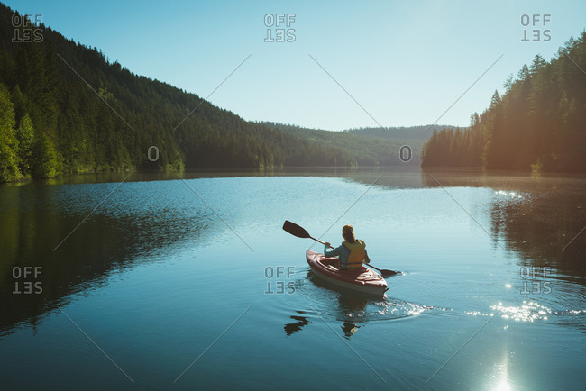 Man kayaking in river on a sunny day