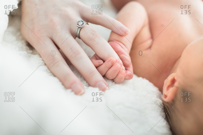 Newborn baby gripping mother's finger