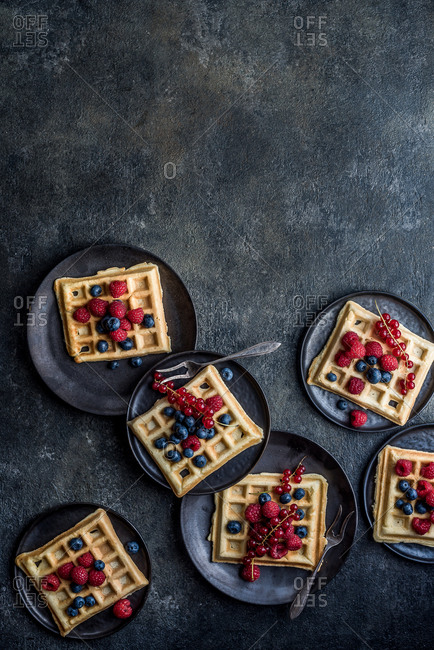 Waffles with berries on plates
