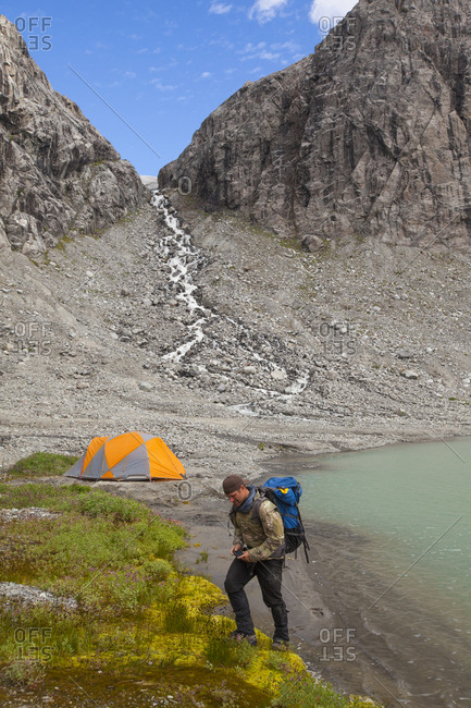 A hiker leaves his lakeside mountain campsite, Garibaldi Provincial Park
