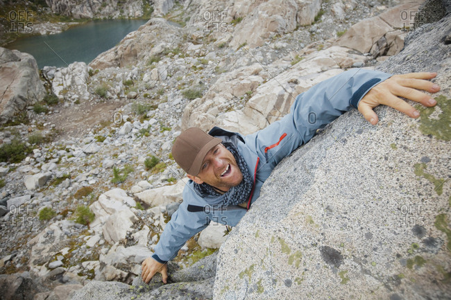 A man with a brown hat climbs a boulder, Garibaldi Provincial Park